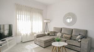 a living room with a couch and a tv at Casa Vesalia a 1a línea de mar con AA y Wi-Fi. in Vinarós