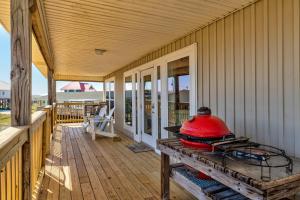 a porch with a red pot on a wooden table at Just Chillin' in Dauphin Island