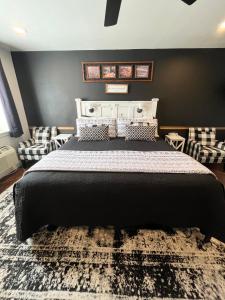 1 dormitorio con 1 cama grande y pared negra en The Panguitch House, en Panguitch