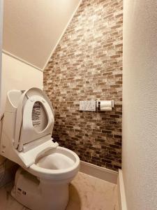 東京にあるNANA HOUSEのレンガの壁のバスルーム(トイレ付)