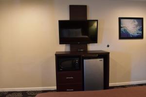 a flat screen tv on a stand with a microwave at Country Inn in Santa Rosa
