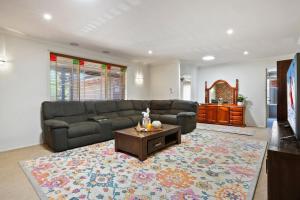 uma sala de estar com um sofá e uma mesa de centro em Casa del Sol em Kiama