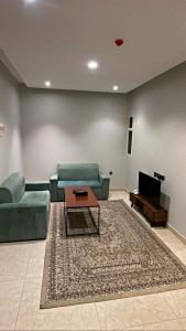 uma sala de estar com um sofá e uma mesa em أضواء الشرق للشقق الفندقية Adwaa Al Sharq Hotel Apartments em Sīdī Ḩamzah