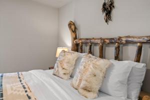 a bed with white pillows and a wooden headboard at Dreamcatcher in West Yellowstone
