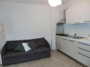 比比翁的住宿－Lovely modern apartment in Bibione - Beahost，小厨房配有一张沙发,设有水槽