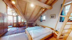 - une chambre avec un lit et un plafond en bois dans l'établissement Abitaziun Chesa Talvo - S-chanf, à S-chanf