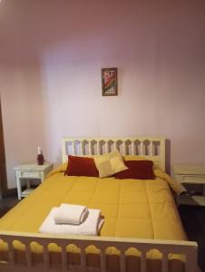 Un dormitorio con una gran cama amarilla con toallas. en Hostal San Alfonso en San Alfonso