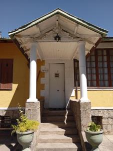 una puerta de entrada de una casa con dos ollas grandes en Hostal San Alfonso en San Alfonso