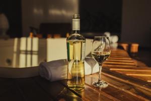 uma garrafa de vinho e um copo sobre uma mesa em Cerejeira Guest House em Campos do Jordão