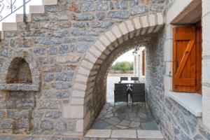 un arco en una pared de piedra con una puerta de madera en Casa Terra Mani, en Álika