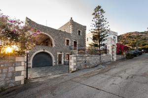 un antiguo edificio de piedra con un garaje en una calle en Casa Terra Mani, en Álika