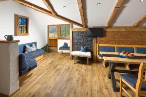 a living room with wooden flooring and a fireplace at Gästehaus Kaltbachhäusl Garni in Ramsau