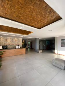 a living room with a wooden ceiling and a lobby at Varandas ao mar loft 302 Praia Grande in Arraial do Cabo