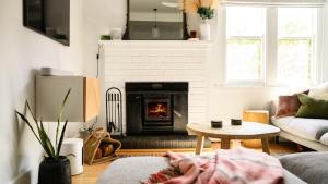 a living room with a fireplace and a couch at Higgins House in Hepburn Springs