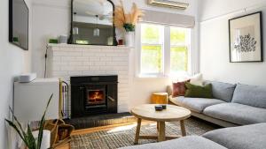 a living room with a couch and a fireplace at Higgins House in Hepburn Springs