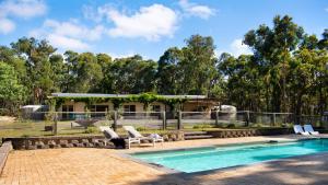 a swimming pool with chairs and a house at Forest Estate Daylesford in Glenlyon