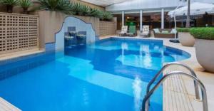 a large blue swimming pool in a hotel at Hotel Funchal JK - Itaim BiBi - Urban Duplex Deluxe Studio - First Class - Collors Edition - By HouseNN in Sao Paulo