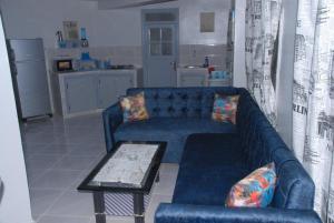 a living room with a blue couch and a table at Élégant Studio in Meknès