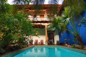 a swimming pool in front of a house with trees at Miss Margrits in Granada