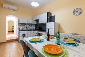 una cucina con tavolo, piatti e bicchieri da vino di Ibla nel Cuore a Ragusa