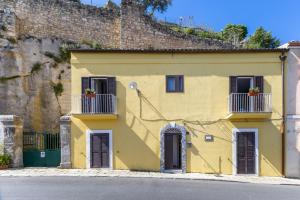 una casa gialla con finestre e balconi su strada di Ibla nel Cuore a Ragusa