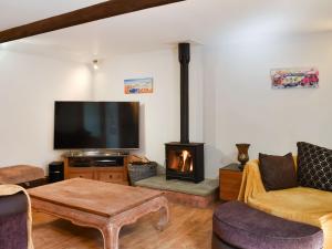 a living room with a fireplace and a tv at Cobblers Retreat in Birley