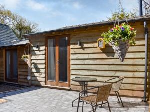 a patio with a table and chairs in front of a cabin at Cobblers Retreat in Birley