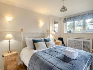 a bedroom with a large bed with blue sheets and pillows at The Old Bakehouse in Overstrand