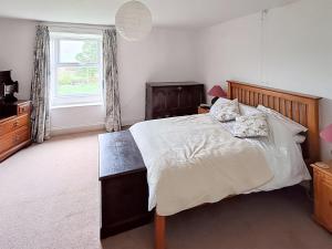 a bedroom with a large bed and a window at Lilac Cottage in Hawes