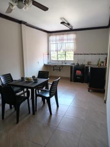a dining room with a table and chairs and a kitchen at Departamentos San Luis in Tarija