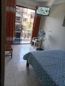 a bedroom with a bed and a flat screen tv at Departamentos San Luis in Tarija