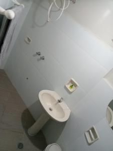 a white bathroom with a sink and a toilet at Departamentos San Luis in Tarija