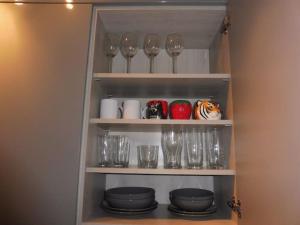 a cupboard with wine glasses and plates in it at 21 Stafford Street (GFR) in Aberdeen