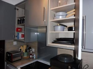 a kitchen with a stove and shelves with pots and pans at 21 Stafford Street (GFR) in Aberdeen