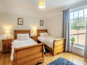 a bedroom with two beds and a window at Forsythia House in Overstrand