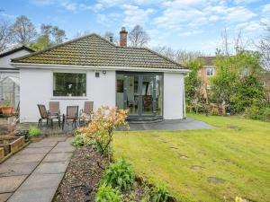 a white house with a patio and a yard at Forest View Cottage in Nottingham