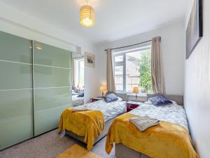 a bedroom with two beds and a window at Forest View Cottage in Nottingham