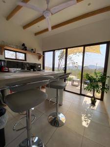 een keuken met een aanrecht en krukken in een kamer bij Cozy Cottage on hilltop near Conchal - Casa Huella in Matapalo