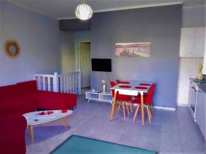 ein Wohnzimmer mit einem roten Sofa und einem Tisch in der Unterkunft Rafaela’s House in Skiathos-Stadt