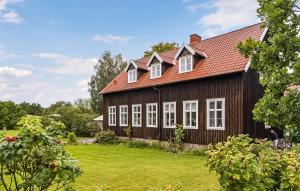 une maison avec un toit rouge et une cour dans l'établissement 1 Bedroom Awesome Apartment In Stenkullen, à Stenkullen