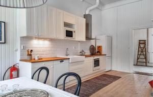 een keuken met witte kasten en een witte koelkast bij 1 Bedroom Awesome Apartment In Stenkullen in Stenkullen