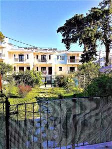 an apartment building with a fence in front of it at Rafaela’s House in Skiathos