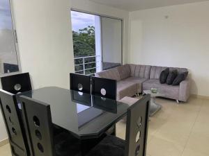 sala de estar con mesa de cristal y sofá en Habitación en Apartamento amplio cómodo y equipado, en Cúcuta