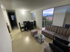 sala de estar con sofá y mesa en Habitación en Apartamento amplio cómodo y equipado, en Cúcuta