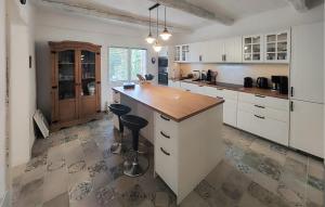a kitchen with white cabinets and a wooden counter top at Awesome Home In Faugres With Private Swimming Pool, Can Be Inside Or Outside in Faugères