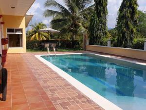 a swimming pool in a villa with a house at Little paradise in Tela