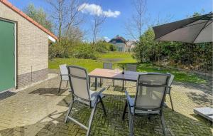 a table and two chairs and an umbrella on a patio at 3 Bedroom Beautiful Home In Makkum in Makkum +24 photos