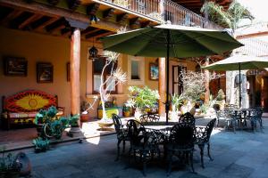 eine Terrasse mit einem Tisch mit Stühlen und einem Sonnenschirm in der Unterkunft Mansion de los Sueños in Pátzcuaro