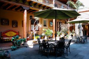 a patio with a table with chairs and an umbrella at Mansion de los Sueños in Pátzcuaro