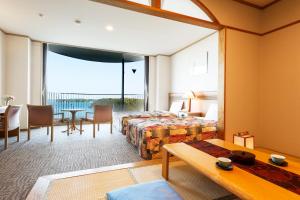 una camera d'albergo con letto, tavolo e sedie di Sunperla Shima a Shima